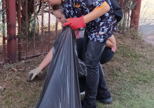 Uczniowie zbierający śmieci.